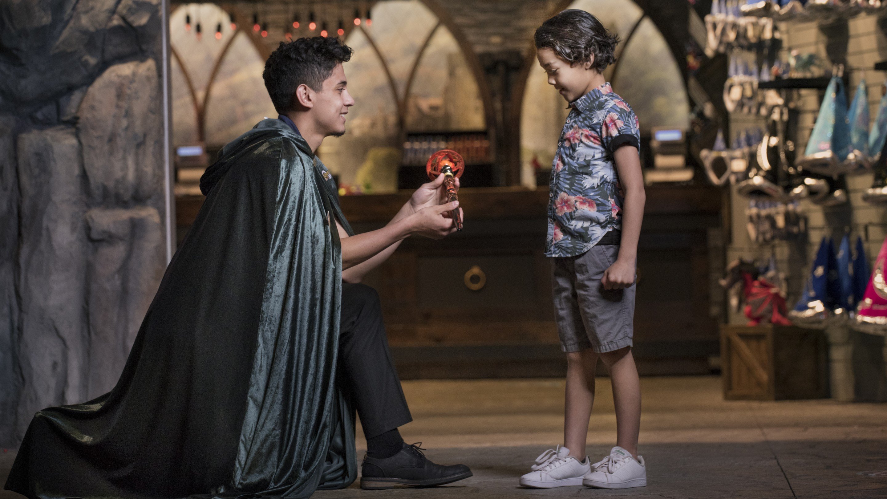 Man presenting magical wand to smiling young boy