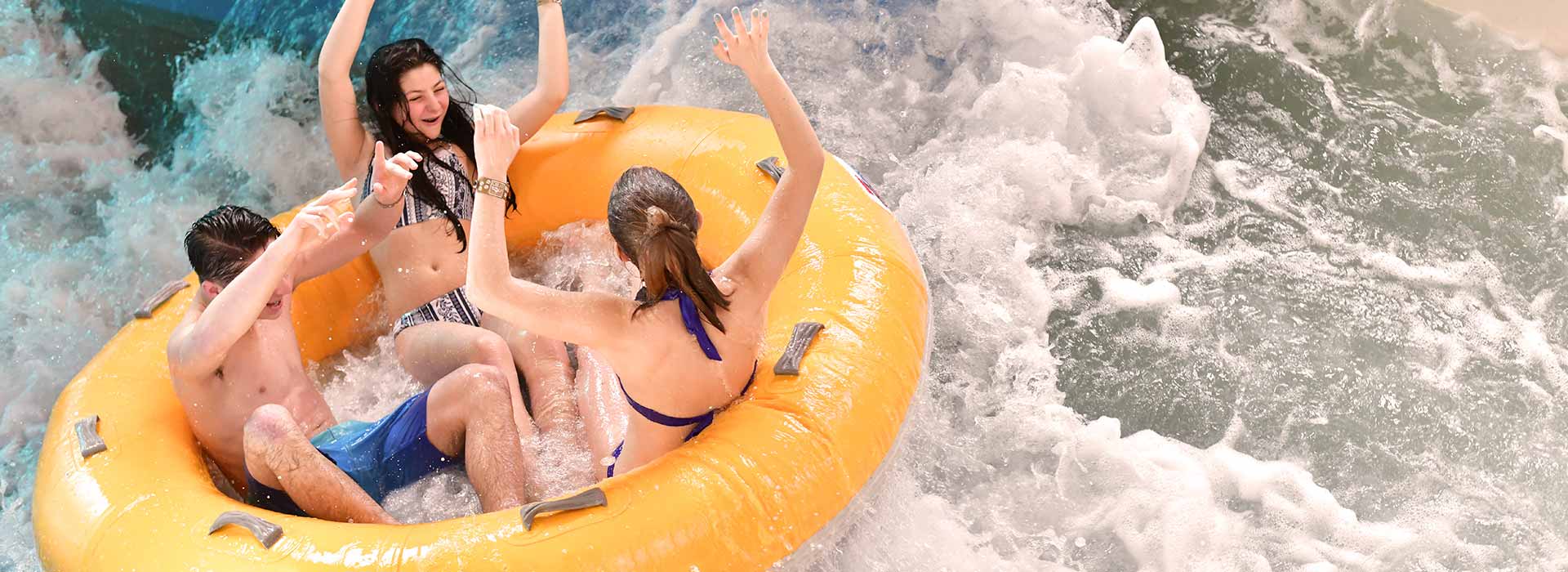 teenagers enjoying a water slide at a Great Wolf Lodge indoor water park.