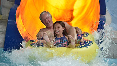 Grandfather and granddaughter on a slide