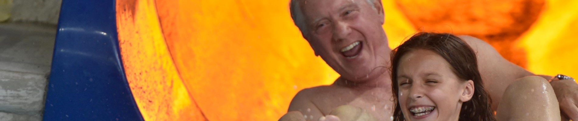 Grandpa and Grand-daughter slide down the water slide 