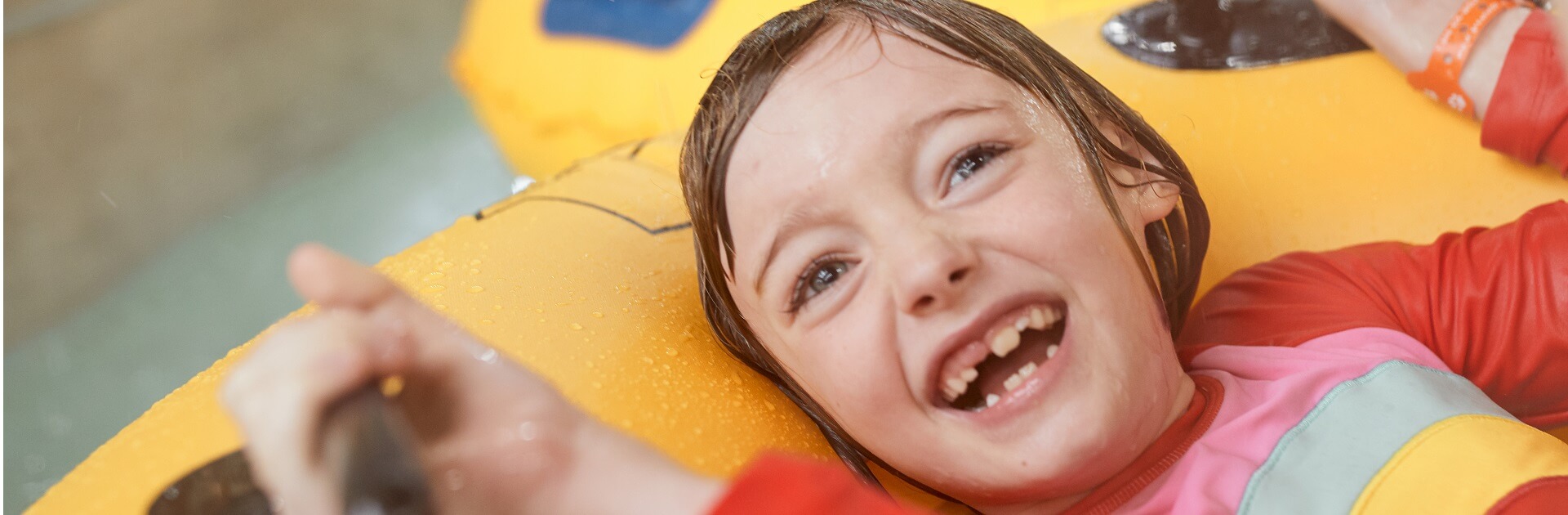 A girl smiles as she tubes along the lazy river
