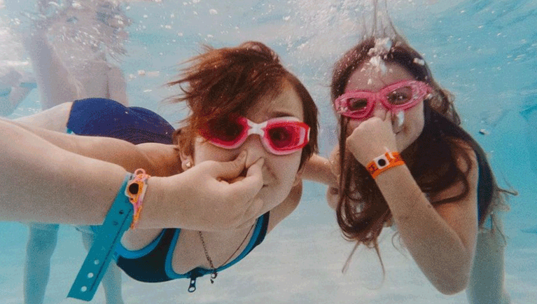 two girls wearing goggles in a swimming pool