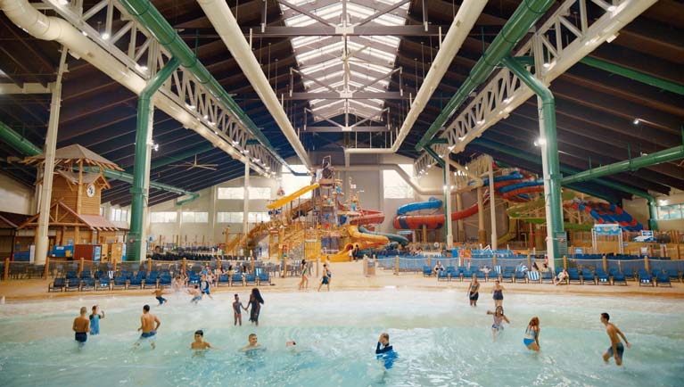 families play in water attractions of indoor water park