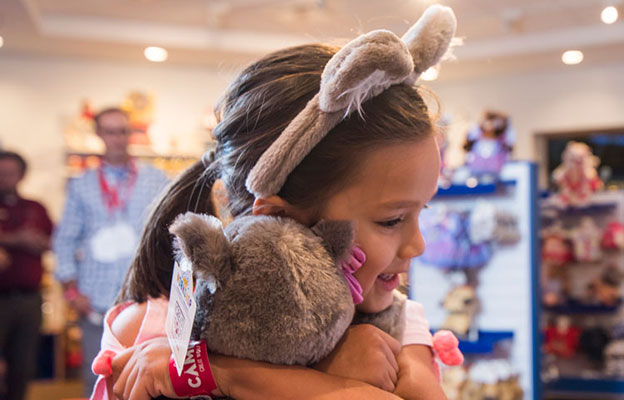 girl in wolf ears hugging a plush bear