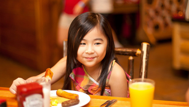 A girl eats breakfast at an Antler Shanty