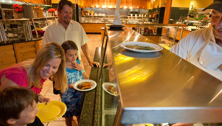 A family of four enjoy a buffet line at an Antler Shanty
