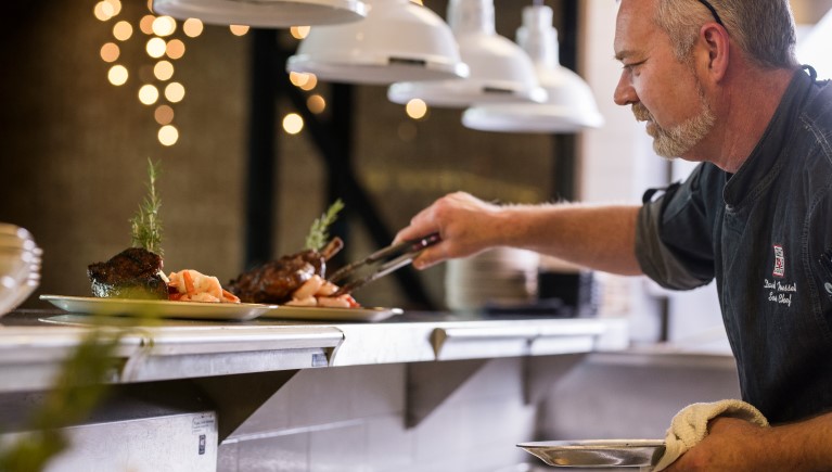 A guest serving himself food at Gitchigoomie Grill 