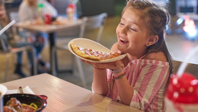 A girl enjoying pizza at Hungry As A Wolf