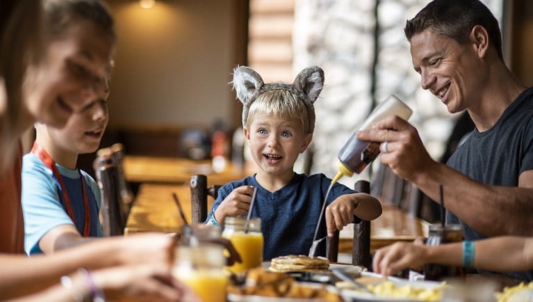 A family enjoying a meal at The Loose Moose Family Kitchen at Great Wolf Lodge indoor water park and resort.
