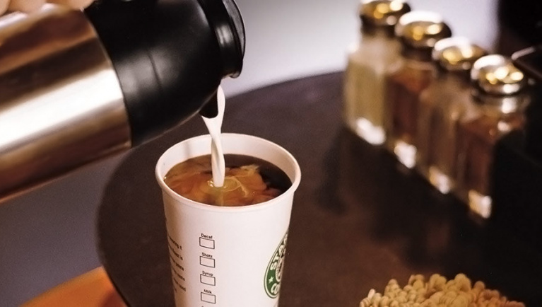 Cream is poured into a Starbucks coffee 