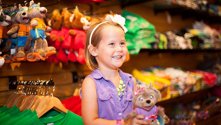 A girl smiles while shopping at Camp H.O.W.L. Kids Store at Great Wolf Lodge indoor water park and resort.