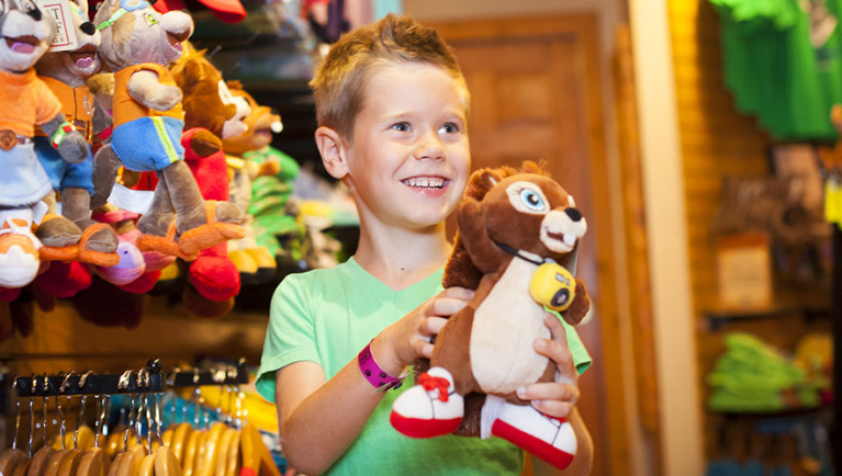 A boy holds up a stuffed animal at The Great Wolf Kids Store at Great Wolf Lodge indoor water park and resort.