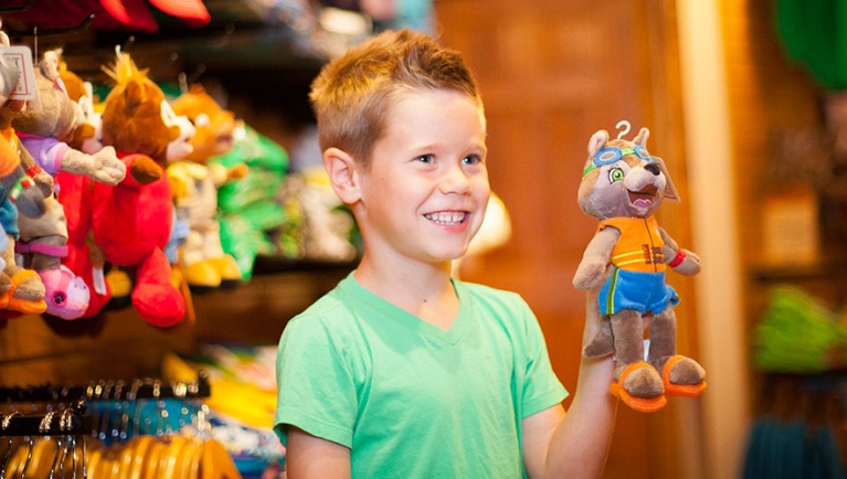 A boy smiles at the camera while shopping 