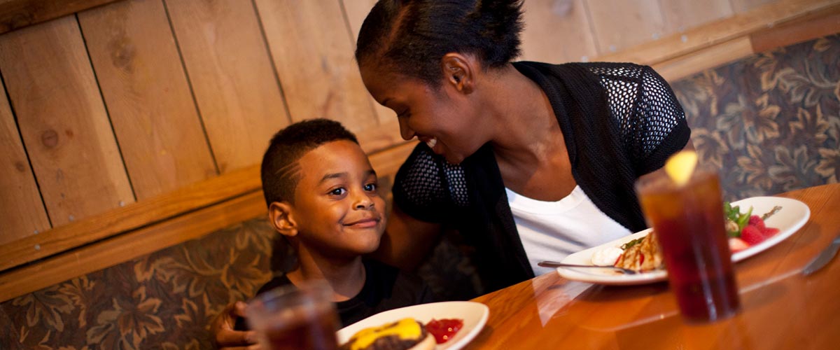 A mother smiles at her son during dinner.