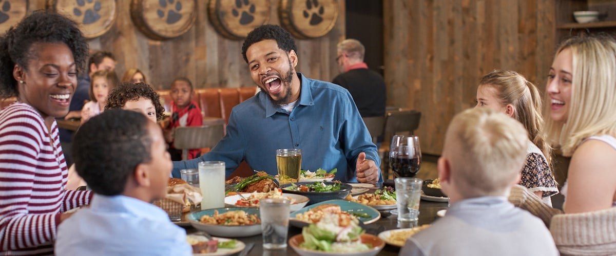 Families have a meal in a booth