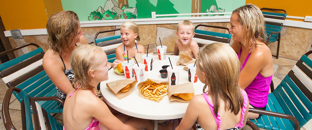 A family of 6 enjoy lunch by the pool