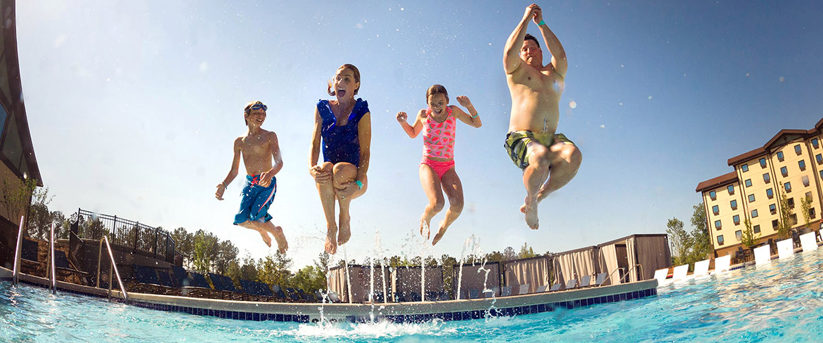 A family jumps into a large pool together