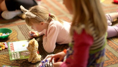 A girl lies on the ground witha coloring book at Great Wolf Lodge indoor water park and resort.