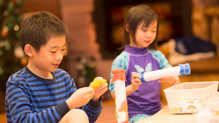 Two kids in wolf ears make crafts