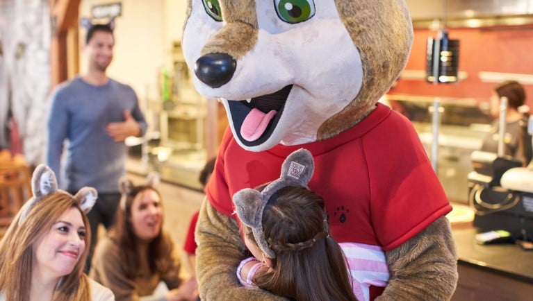 Wiley the Wolf hugs a guest at Great Wolf Lodge indoor water park and resorts.
