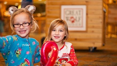 Two girls smile at the camera while at Great Wolf Lodge indoor water park and resort.