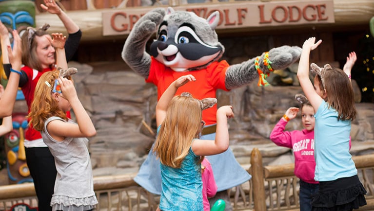 A group of children and a character dance