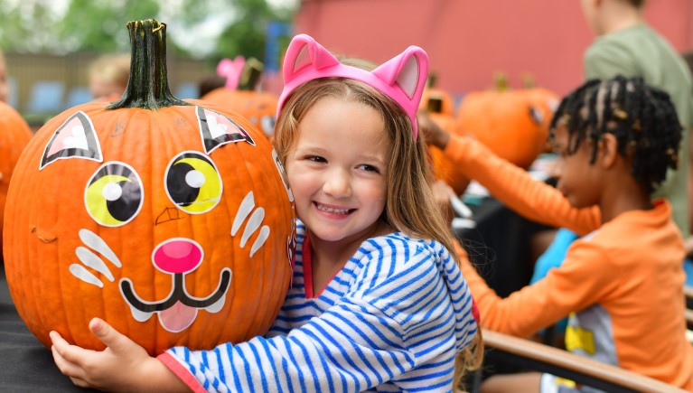 a girl smiling with her pumpkin art