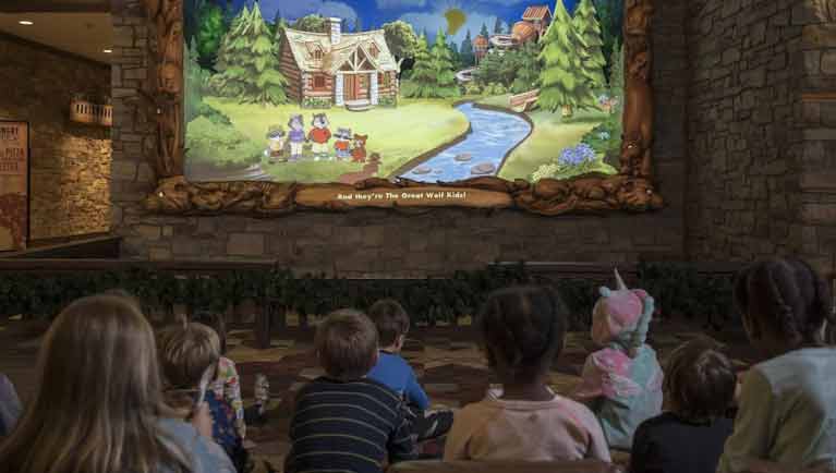 children sit on the ground as they watch a show