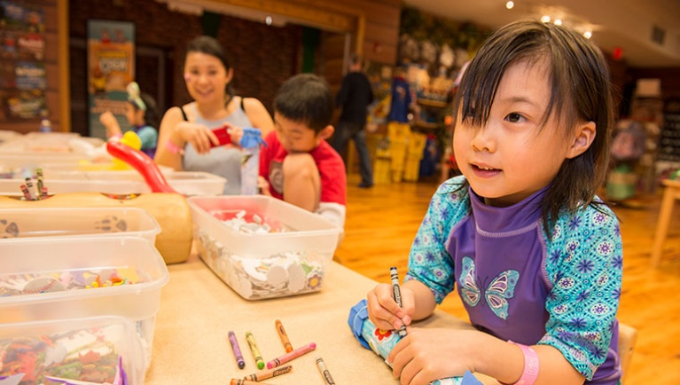 A girl colors her craft project