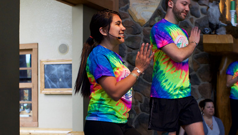 Employees in tie dye shirts leading exercise event 