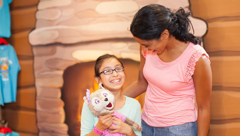 A girl smiles up at her mom at Clubhouse Crew at Great Wolf Lodge indoor water park and resort.