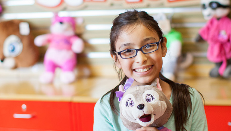 A girl smiles at the camera after a visit to Creation Station at Great Wolf Lodge indoor water park and resort.