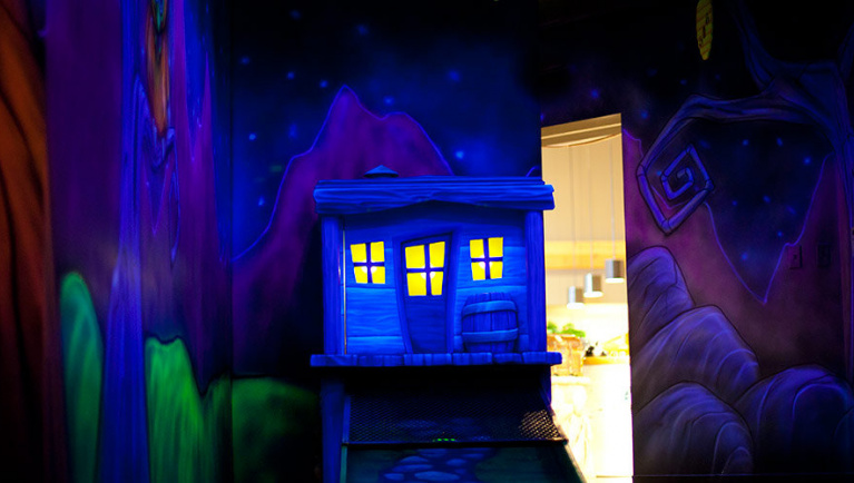 A tiny glowing house feature at Howl at the Moon Glow Golf at Great Wolf Lodge indoor water park and resort.