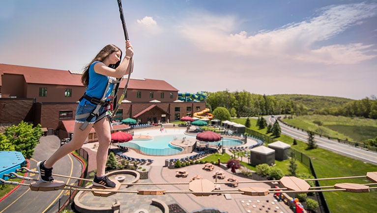 Women attemptes the Howlers Peak Ropes Course at Great Wolf Lodge indoor water park and resort.