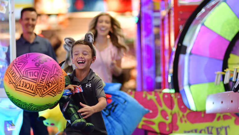 A boy smiles as he holds his prizes at Northern Lights Arcade at Great Wolf Lodge indoor water park and resort.