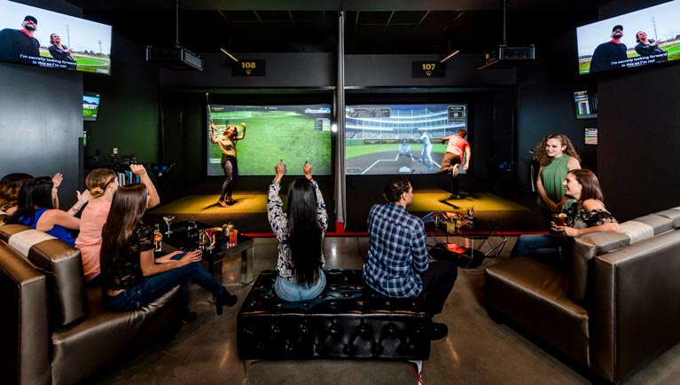 A group enjoys virtual golf and virtual baseball