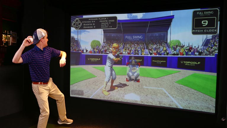 Man winds up to pitch for virtual baseball game