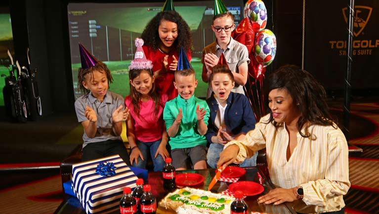 Woman cuts cake and children clap