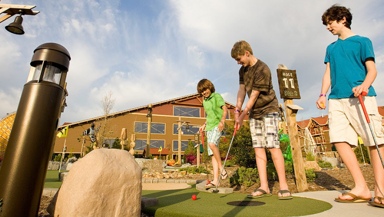 A family plays Wacky Wilderness Mini Golf at Great Wolf Lodge indoor water park and resort.