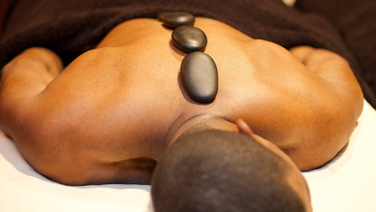 Man with massage rocks at the spa at Great Wolf Lodge indoor water park and resort.