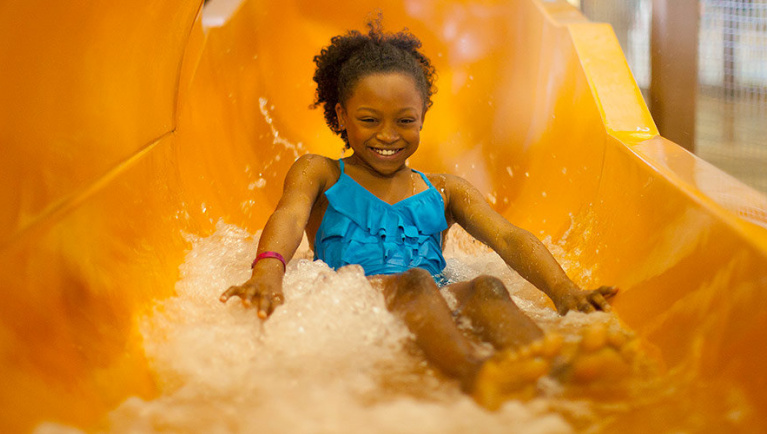 Child splashes going down the Beaver Falls at Great Wolf Lodge indoor water park and resort.
