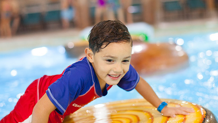 A boy balances on a lily pad float in Big Foot Pass