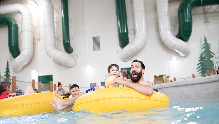 A father holds his son as they float down the lazy river