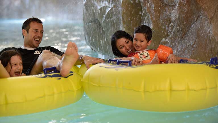 A father holds his son as they float down the lazy river