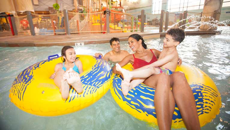 A family float down the lazy river excitedly in her inner tube