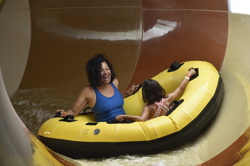 A family rides the Diamond Back Drop water slide