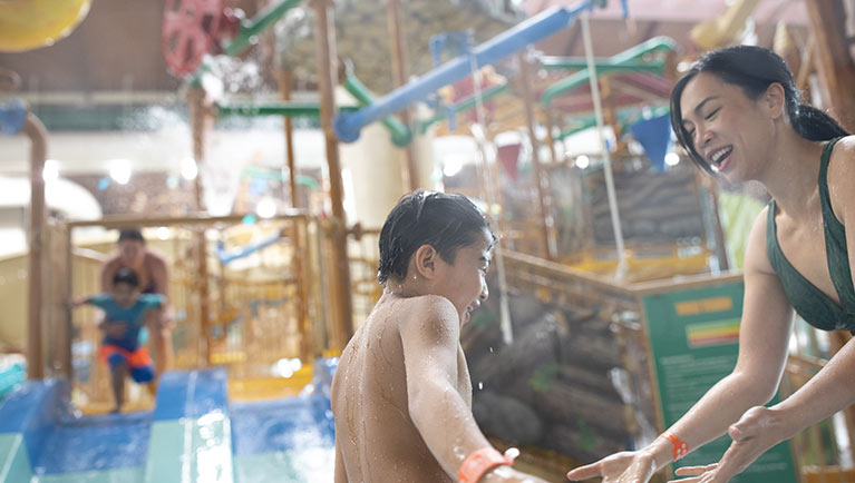 A mom playing with her son at Talking Stick Treehouse located at a Great Wolf Lodge indoor waterpark and resort.