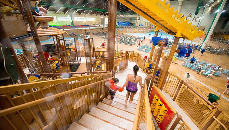 A mother helps her son down the stairs at Fort Mackenzie located at a Great Wolf Lodge indoor water park.