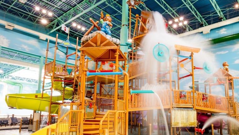 A wide shot of the Fort Mackenzie water treehouse at a Great Wolf Lodge indoor water park.
