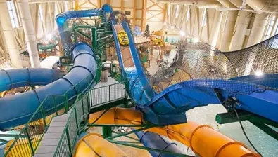 view of the indoor water park with a yellow and blue slide 